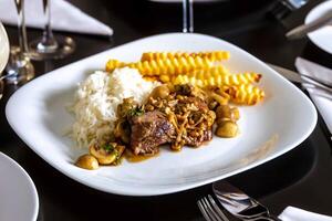 Luxurious and exquisite dish, filet mignon with mushroom sauce accompanied by white rice and French fries. Filet mignon with rust sauce photo