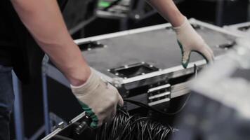 Worker coiling cables above transport case video