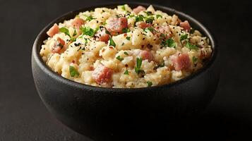Creamy Mashed Potatoes with Ham and Parsley in a Black Bowl. A close up photo of a delicious and comforting meal.