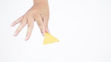 Hand holds yellow nachos chips isolated on white background photo
