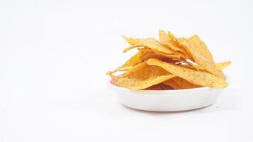 Crispy tortilla chips on small plate isolated on white background photo