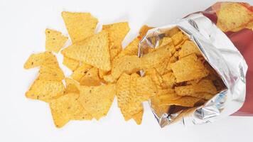 Tortilla chips spilled out from tortilla bag isolated on white background photo