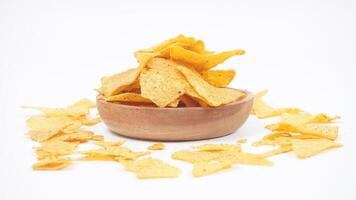 Tortilla chips on a plate and scattered around the plate isolated on white background photo