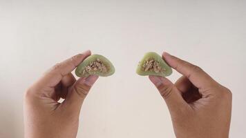 Hands holding traditional Indonesian snack dessert made from glutinous rice flour, Kue Bugis photo