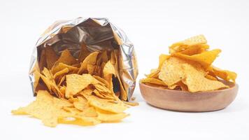 Tortilla chips spilled out from tortilla bag with a plate of tortilla isolated on white background photo