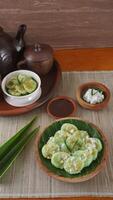 Kue Lupis, legend of traditional Indonesia rice cake dessert snack with grated coconut and palm sugar syrup, on platters photo