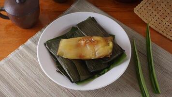 Lemet, traditional Indonesian dessert snack made from cassava, wrapped in banana leave, and steamed photo
