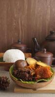 Gudeg, a traditional Javanese dish from Yogyakarta, Indonesia, made primarily from young unripe jackfruit or nangka with several side dishes and a plate of rice photo
