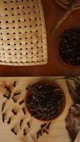 Top view of cloves spice on wooden platters isolated on wooden texture background photo