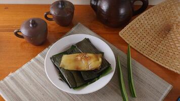 Lemet, traditional Indonesian sweet snack made from cassava, wrapped in banana leave, and steamed photo