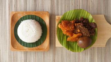 Top view of Gudeg, a popular traditional Javanese dish from Yogyakarta, Indonesia, made primarily from young unripe jackfruit or nangka with several side dishes photo