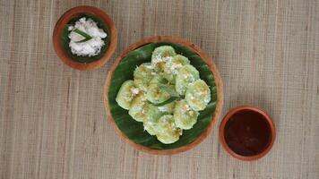 Top view of Kue Lupis, a traditional Indonesia rice cake dessert snack with grated coconut and palm sugar syrup, on wooden plates photo