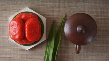 Top view of Kue Mata Kebo means buffalo eye cake, traditional Indonesian snack made from glutinous rice flour, on white platter with pottery tea cup photo