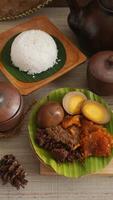Selective focus of Gudeg, a traditional Javanese dish from Yogyakarta, Indonesia, made primarily from young unripe jackfruit or nangka with several side dishes and a plate of rice photo