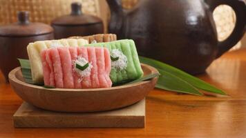 Selective focus of Gethuk, a traditional Indonesian snack made from steamed and mashed cassava with sugar in various colors with grated coconut topping photo