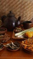 Selective focus of composition of Wedang Uwuh, traditional Indonesian herbal drink that consist of sappan wood, cinnamon, ginger, lemongrass, and pala leaves photo