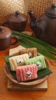 Selective focus of Gethuk, a delicious traditional Indonesian snack made from steamed and mashed cassava in various colors with grated coconut topping photo