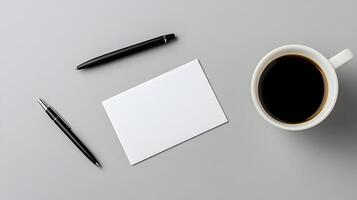 Blank business card mockup on neutral desk surface with coffee and pen photo