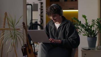 Cheerful Caucasian man trader use computer laptop male browsing website Internet guy chatting online glad hipster freelancer working remote digital job at home broker searching information cyberspace video