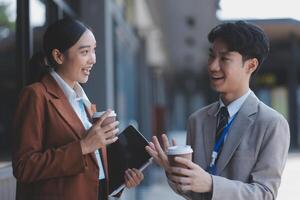 Asian business couple talking and drinking coffee photo