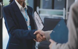 A woman in a business suit shaking hands with another person photo