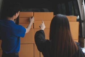 A man and woman are loading boxes into a van photo