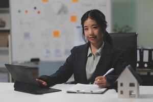 A woman in a business suit sitting at a desk with a laptop photo