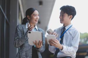 Asian business couple using tablet pc and smartphone photo