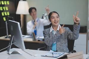A woman in a business suit is pointing at her computer screen photo