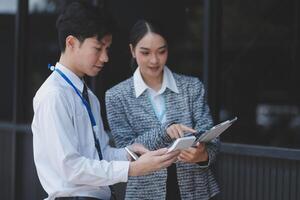 Asian business couple using tablet pc in office photo