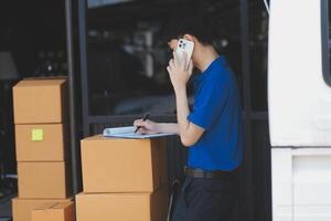 A man standing near a van with boxes and a phone photo