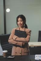 A woman in a business suit standing in front of a desk photo