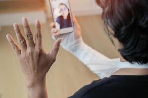 A man in a black T-shirt with a broken arm in a cast holds and uses a phone and call to his friend. photo