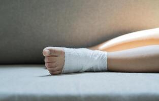 Close-up and selective focus of child ankle joint pain with bandage gauze as. photo