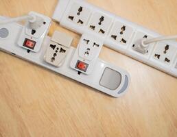 Top view of plugs in extension cords - from the Offset collection on wooden table. photo
