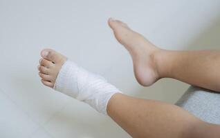 Top view of bandaged feet of a child because of a little accident after falling down. photo