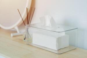 Selective focus of clear plastic box with napkin and mirror, reed diffuser on wooden table photo