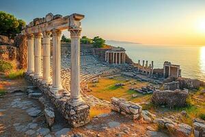 The tall white columns of the ancient temple are located on the top in front of the sea. photo