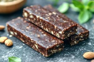 Healthy homemade raw protein bars with nuts and seeds displayed on dark surface photo