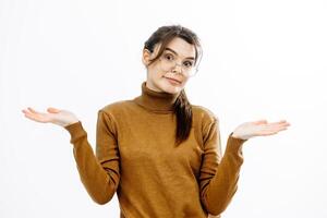 A young woman shows her hands in a oh sorry gesture. Doesn't know or has no idea, she has nothing to say, standing against a white background. The concept of justification or ignorance photo