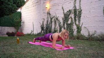Empowered mother demonstrates effective core workout in serene garden setting video