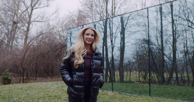 A woman in a black jacket reflects on herself in mirrored surfaces video