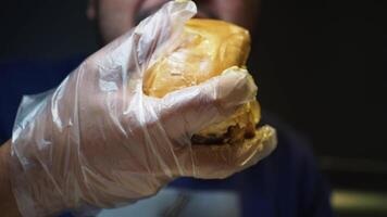 Eating a tasty burger with gloves at a local spot video