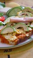 Enjoy a hearty open-faced sandwich with egg, avocado, and ham on bread video
