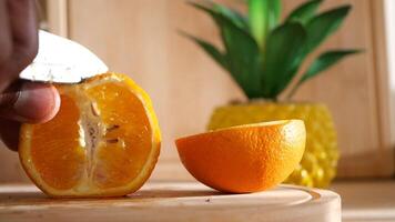 Fresh orange being sliced in bright kitchen setting video