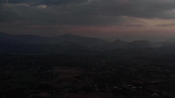Panoramic view of smoky hills at dusk with rolling terrain, misty mountains, and a moody sky transitioning from sunset to night, capturing serene natural beauty video