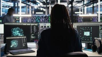 Server farm software developer interprets data analytics graphs. Data center specialist using artificial intelligence program showing predictive system metrics, camera A video