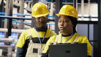 Engineering team working together, overseeing solar panel production lines equipment. Teamworking colleagues maintaining photovoltaic assembly systems in automated industry 4.0 factory, camera B video