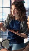 Vertical Man and woman collaborate on content creation for the media industry, analyzing data and insights, editing footage and adjusting branding elements. AI powered. Camera B. video