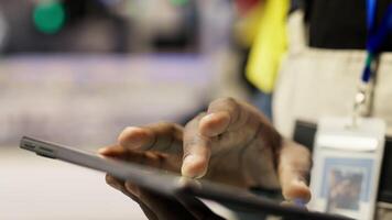 Close up of tablet used by smart factory specialist to implement automated workflows and control systems, computerizing operations. Industry 4.0 plant worker automates production with device, camera B video